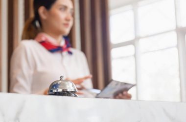 Hotel front desk staff using a tablet next to a service bell
