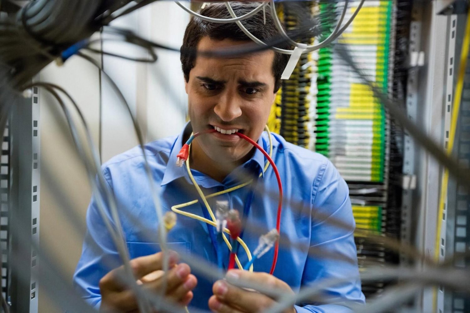 Frustrated IT technician untangling network cables during an unexpected server outage