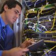 IT engineer inspecting a server rack with a tablet during a routine maintenance check at a Dubai office