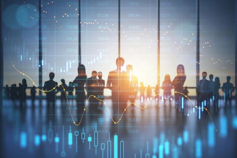 Silhouettes of business executives against a stock chart, illustrating background screening as a risk management tool in the UAE