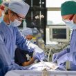 Operating theatre view of a hernia surgery procedure with monitors and full surgical team